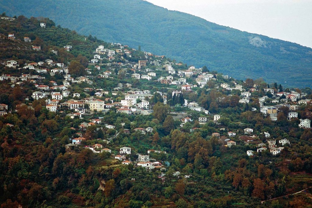 The houses of Zagora spread across a wooded slope in autumn colours