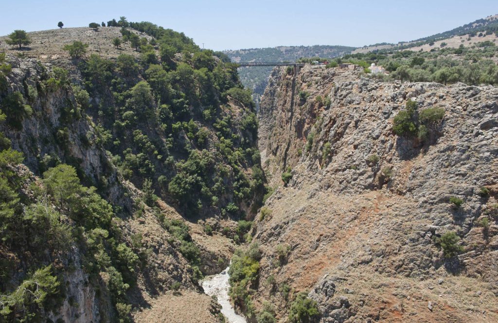 Deep gorge with vertical rock walls seen from above, with trees along its rim
