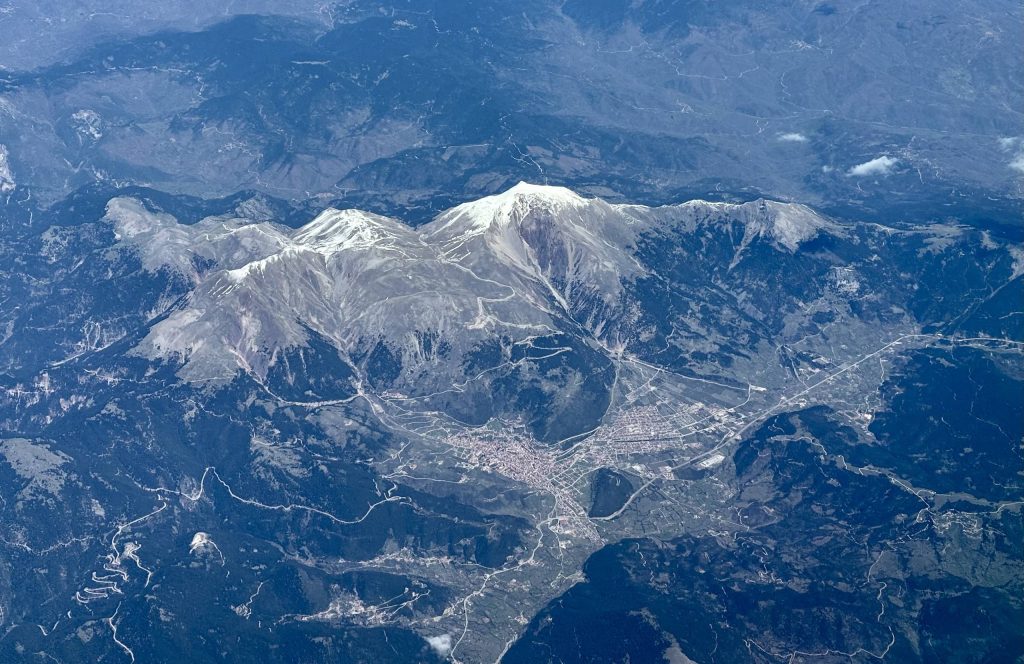 Aerial view of snow-covered Mount Tymfristos, with the town of Karpenisi in the valley below