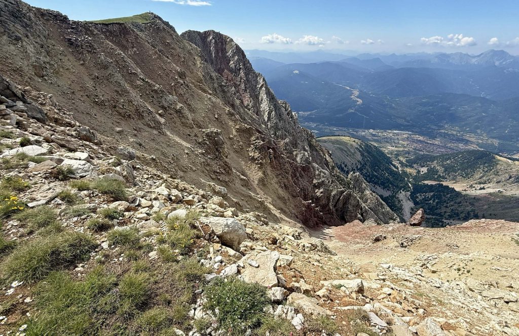 The steep southwestern side of Mount Tymfristos seen from the summit, with valleys and ridges beyond