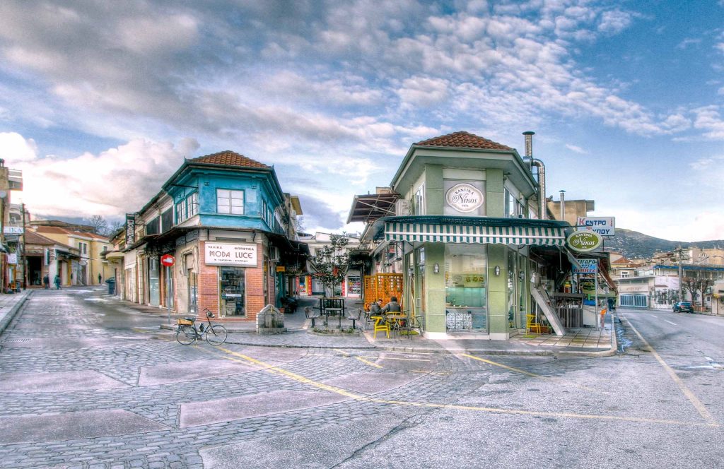 Row of colorful traditional heritage buildings along a street in Drama's market area.