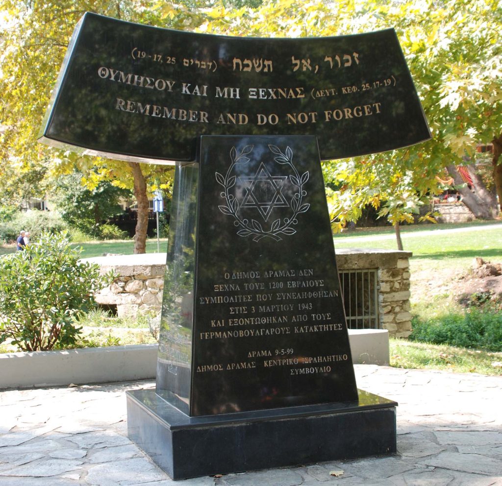 Tall black stone monument with Hebrew and Greek inscriptions, commemorating Jewish victims from Drama.