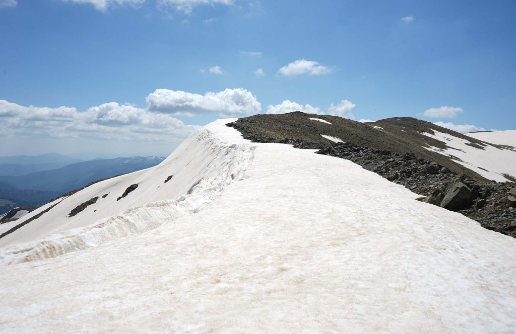 The snow-covered summit ridge of Mount Vasilitsa, with distant ranges of the Pindus on the left