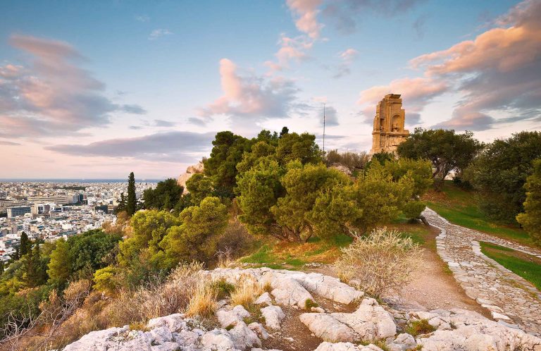 Ancient tower ruins on a hilltop overlooking the sprawling city of Athens