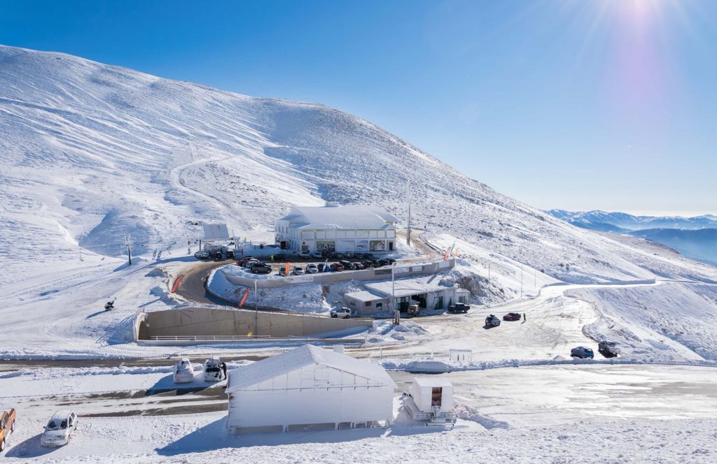 Buildings and car park of the Velouchi ski centre on a snow-covered plateau